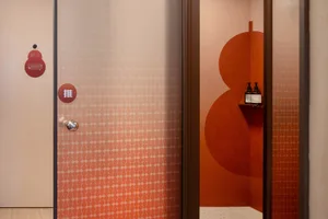 An image depicting an orange terrazzo-patterned bathroom wall and floor design.