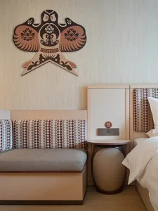 Minimalist hotel room with textured wallpaper, bed, and cushioned seating area.