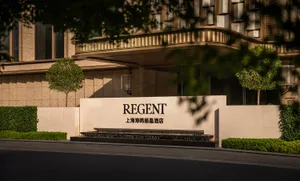 The entrance of a modern hotel featuring a concrete façade.