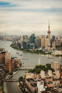 Aerial view of Shanghai skyline and river with boats.