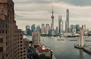 A panoramic view of a modern cityscape featuring contemporary skyscrapers and riverfront architecture.