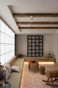 A modern minimalist living space featuring wooden furniture, stone accents, and paper cushions.