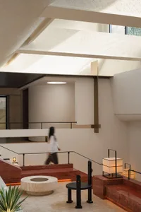 Modern home interior featuring concrete walls, marble accents, and brass fixtures.