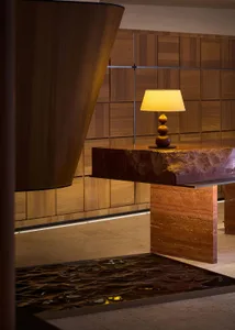 A modern hotel lobby featuring wooden walls, concrete tables, and rustic elements.
