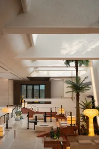 A modern lobby with concrete, wood, and glass elements.