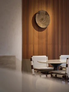 Modern restaurant interior with white leather chairs and wooden paneling wall