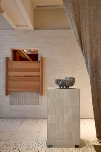A modern interior design featuring ceramic art on a contemporary pedestal.