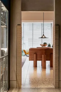 Modern dining room with a wooden table, pendant lamp, and terrazzo flooring.