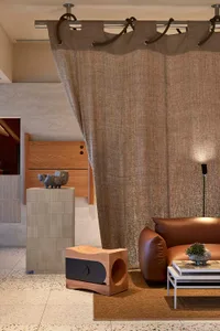 An interior design image featuring a modern living room with textured cloth furniture and minimalist lighting.