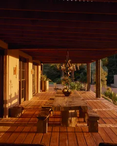 A cozy wooden patio featuring rustic furniture and greenery.
