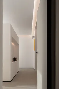 A minimalist white interior with clean lines and a modern design aesthetic, featuring a hallway with a sleek white floor and 