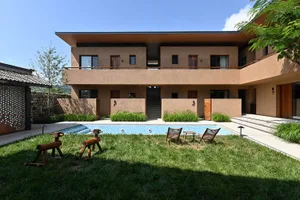 A modern residential building with a swimming pool in its backyard.