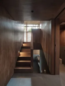 Staircase with wooden paneling leading to a residential space.