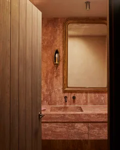 A modern bathroom featuring marble fixtures and a sconce sconce.