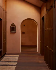 A modern corridor featuring warm-toned wooden walls and a wooden floor.
