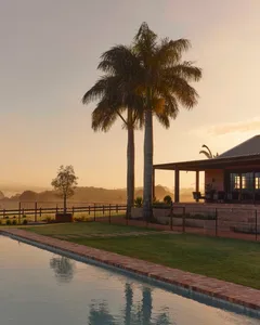A luxurious residential exterior featuring concrete construction and palm trees.