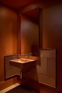 A minimalist bathroom featuring metal, concrete, and terrazzo elements.