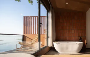 現代浴室採用混凝土地板，獨立式浴缸可俯瞰寧靜海景。