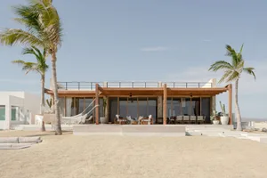 Modern residential beach house with a spacious outdoor area and sand terrace.