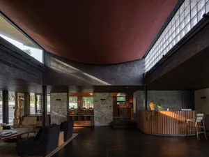 A modern hotel reception area with concrete walls and high ceilings.