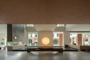 A minimalist living room with concrete flooring and minimalist furniture.