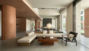 A modern minimalist living room featuring a concrete floor, wood furniture, and a minimalist pendant light.