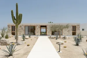 Modern residential architecture featuring sandstone, glass, and steel materials and design elements.