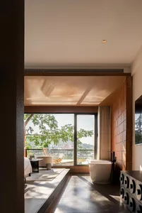 A modern residential bathroom featuring ceramic tiles, glass elements, and metal fixtures.
