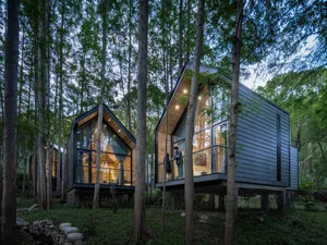 Modern residential exterior with wooden siding and large glass windows.