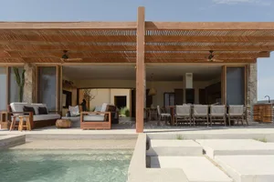 An image of a modern residential wooden porch with a pool in front.