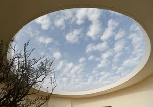 A modern architectural design featuring a circular glass skylight.