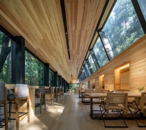 Industrial-style cafe interior with wooden walls and large windows.