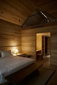 Minimalist bedroom featuring wooden walls and a cozy atmosphere