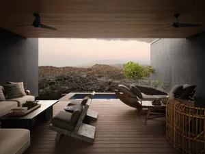 A minimalist residential patio featuring wood flooring and furniture, with a serene outdoor space and a small pool.