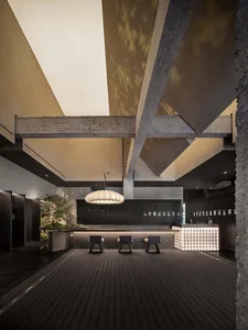 Modern lobby interior with concrete ceiling beams and wood accents
