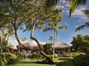 A residential villa with a thatched roof and wooden exterior.