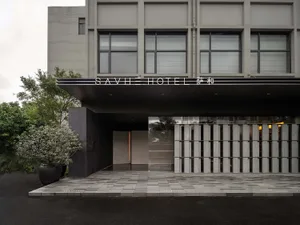 SAVHE Hotel entrance featuring concrete and glass materials.