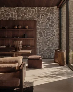 A cozy, rustic industrial living room with stone, concrete, and reclaimed wood elements.