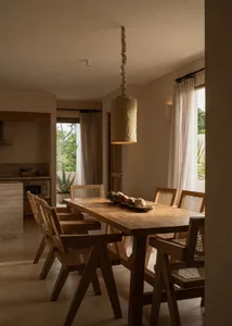 Modern dining room featuring wooden furniture, organic lighting, and a minimalist design.