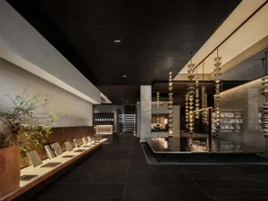 A modern hotel lobby featuring exposed concrete and metallic elements.