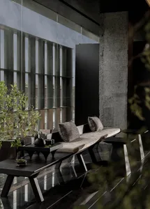 Modern interior design featuring a sleek, minimalist living area with wooden furniture, a concrete wall, and a large window.