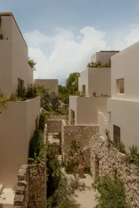 A modern minimalist residential building with stone and concrete features.