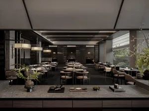 Modern restaurant interior with dark wood furniture, marble countertops, and minimalist design.