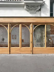 The storefront of a retail store with large glass windows and wooden panels.