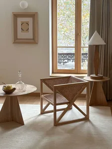 A modern living room with wooden side tables, a rattan chair, and a triangular lamp.
