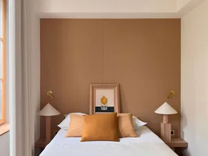 A minimalist bedroom with a bed featuring wood and concrete elements.