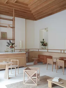 Modern cafe bar with light wood interior, featuring minimalist design and comfortable seating.