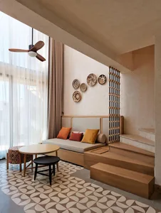Modern interior with wooden staircase, bench, and colorful pillows.