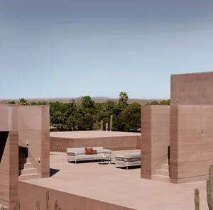 Minimalist outdoor lounge space featuring concrete walls and seating with brown accents.