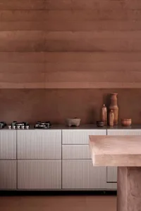 Modern residential kitchen featuring concrete cabinets with marble countertops and minimalist design.